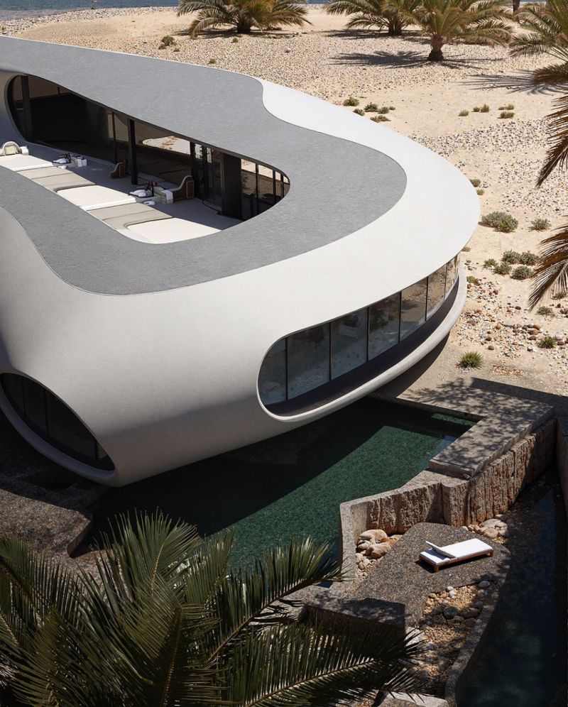 A curved, monolithic white beach house with a rooftop lounge deck and a sunken stone plunge pool