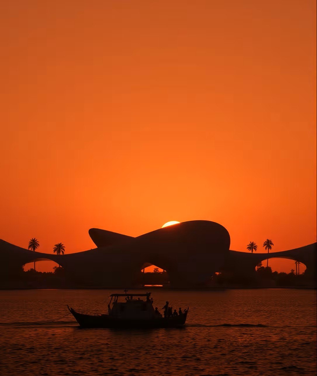 silhouetted, wave-roofed building